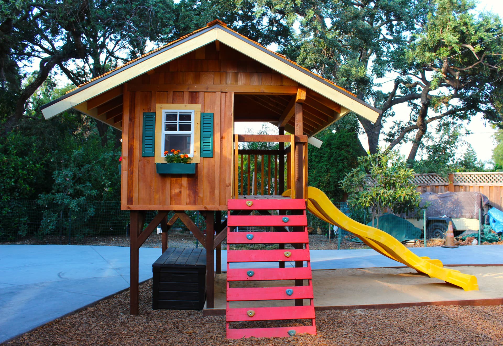 The climbing wall and slide leading up to the playhouse