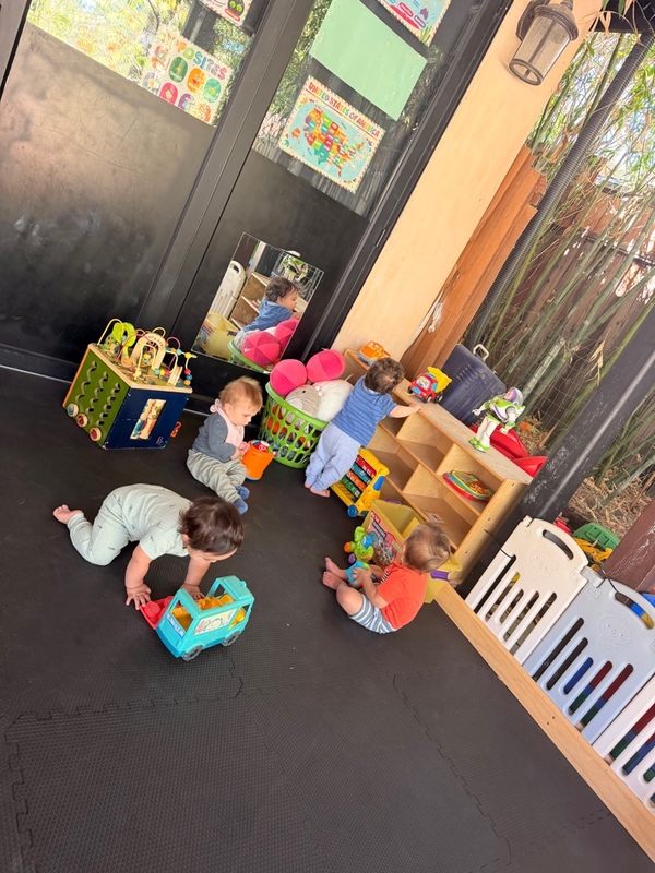 Babies playing and discovering toys in the outdoor infant gym