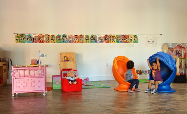 Two toddlers playing pretend in the cozy play corner