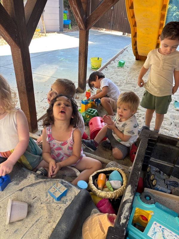 Preschool children exploring sand play together