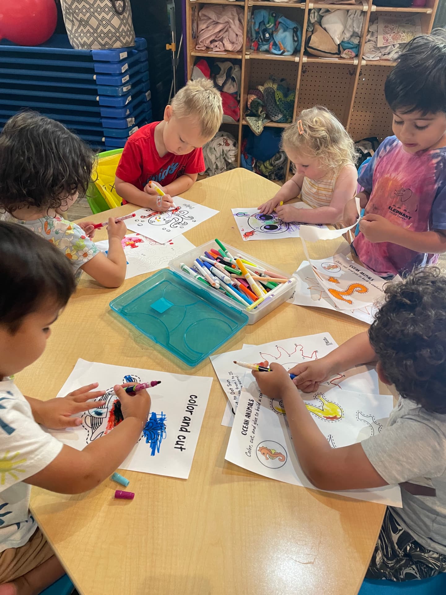 Preschool children coloring ocean animals together at art time