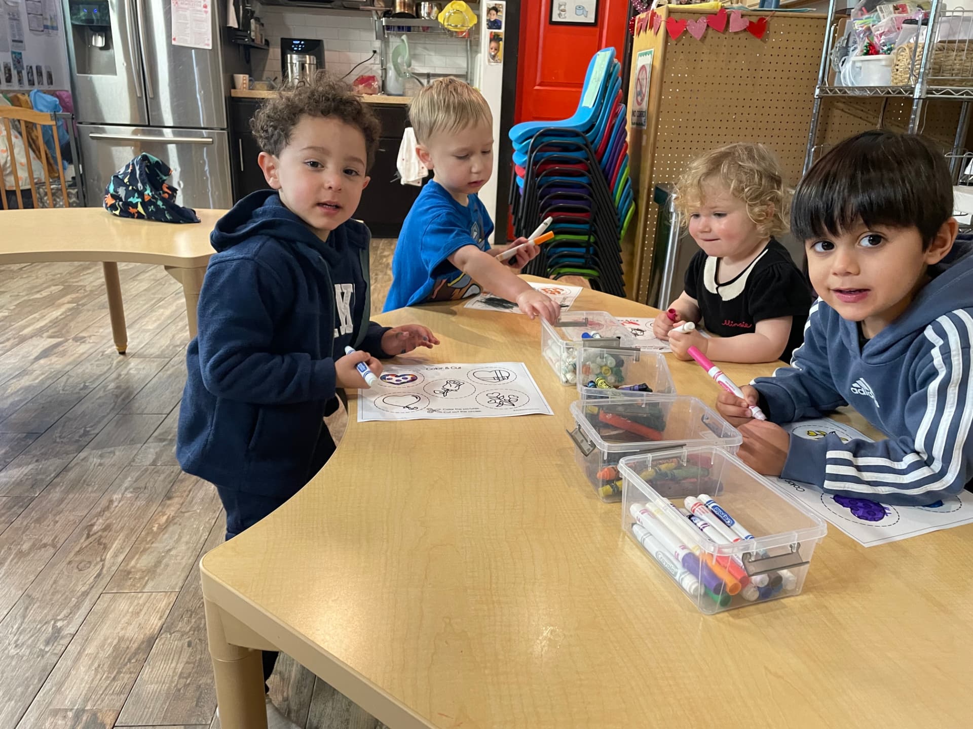 Preschool children drawing together at a classroom table